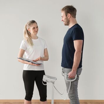 Mann steht auf einer Biawaage und wird von einer Frau getestet